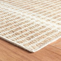 a close up view of a rug on the floor with wood and white carpeting