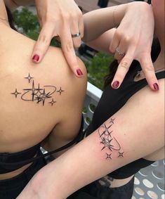 two women with matching tattoos on their backs