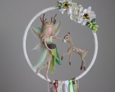 a glass ornament with an image of a deer and a fairy on it