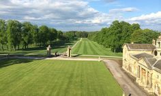 an aerial view of a large grassy field next to a building with statues on it