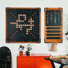 two pieces of wood are on the wall next to an orange cabinet and potted plant