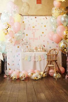 a baby shower party with balloons and confetti on the table, chairs and backdrop