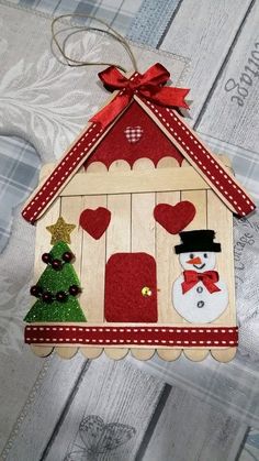 a wooden ornament hanging on a wall with a christmas tree and snowman