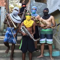 some people are standing on the steps with instruments in their hands and wearing bandanas