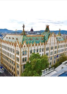 an aerial view of a large building with many windows and gold trim on it's roof