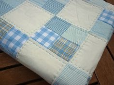 a blue and white patchwork pillow on a wooden bench