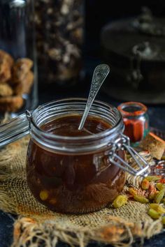 there is a spoon in a jar with some food on the table next to it