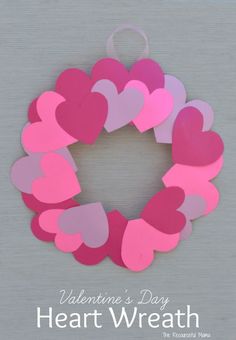 a valentine's day heart wreath made out of pink and purple paper on a gray background