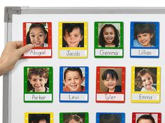 a person holding up a white board with pictures of children in different languages on it