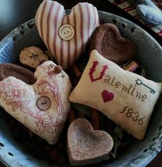 a bowl filled with hearts and pillows on top of a table