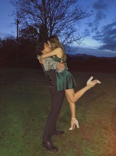 a man and woman are hugging in the grass