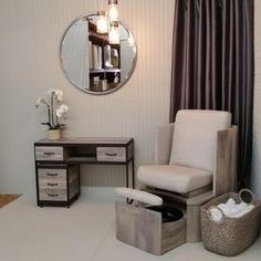 a white chair sitting in front of a mirror on top of a wall next to a dresser