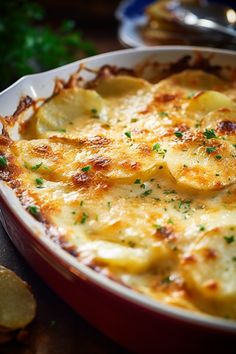 a casserole dish with potatoes and parmesan cheese in it on a table