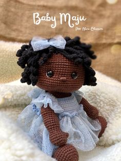 a crocheted doll sitting on top of a blanket