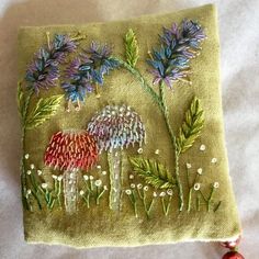 an embroidered purse with flowers and leaves on it