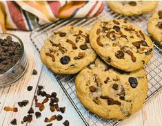 chocolate chip cookies cooling on a wire rack with raisins next to the cookie