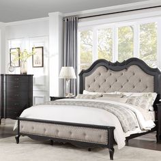 a bedroom with a large bed, dresser and mirror in it's center area