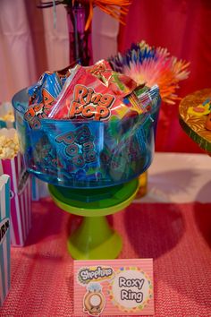 there is a candy bowl on the table with other snacks in it and some popcorn