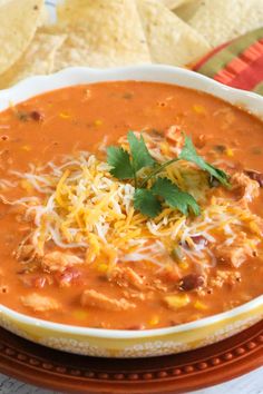 a bowl of chili cheese soup with tortilla chips