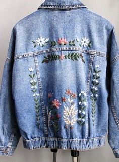 a denim jacket with flowers and leaves embroidered on it