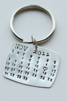 a metal keychain with a calendar on the front and numbers on the back