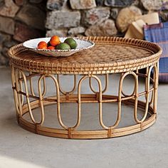 a wicker coffee table with fruit on top