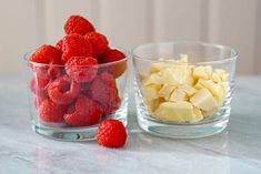 two bowls filled with raspberries and cubes of cheese next to each other