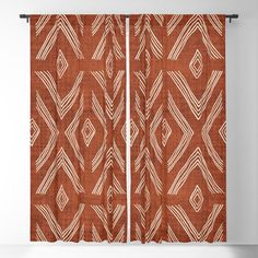 an orange and white patterned curtain hanging on a wall