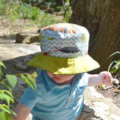 "Baby boy bucket sun hat. Super cute children's spring and summer hat with a bucket brim. Unique, reversible boutique hat handmade with quality workmanship from designer cotton prints. Great for the beach, poolside, or just around town!  You won't find another hat like one of my sun hats.  Features: * Fully reversible. Like having two hats in one! * Bucket-style brim looks great on little boys.  * 100% cotton in designer prints. * Pre-shrunk and machine washable. * Available in size 6-12 months and fits head circumference up to 17.5\" (44 cm) The first side has an adorable print with fish and a chevron pattern. The second side is a blue plaid with orange sand dollars.  To view other size or style options, please visit my shop and browse from the sections on the left: http://www.etsy.com/sh Adjustable Playful Bucket Hat For Playtime, Playful Adjustable Bucket Hat For Playtime, Playful Brimmed Sun Hat For Playtime, Playful Sun Hat With Curved Brim For Playtime, Adjustable Playful Sun Hat For Playtime, Playful Wide Brim Bucket Hat For Playtime, Playful Wide Brim Hat For Playtime, Playful Curved Brim Sun Hat For Playtime, Playful Sun Hat, One Size Fits Most, For Playtime