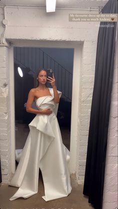 a woman in a white dress taking a selfie