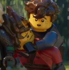 two legos are holding each other in their arms and one is wearing a helmet