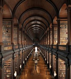 an old library with many bookshelves and benches lined up against the wall,