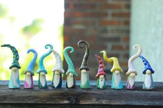 seven colorful ceramic figurines sitting on top of a wooden table