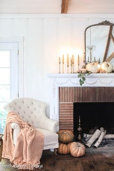 a living room filled with furniture and a fire place in front of a mirror on the wall