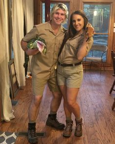 a man and woman dressed in safari clothes posing for a photo together on the floor