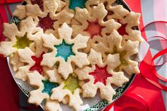 a platter filled with cut out cookies on top of a red and white table cloth