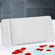 a bathtub with red petals on the side and a memory pillow in the middle