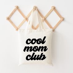 Looking for a cute tote bag to carry all your essentials this summer? This cute Cool Mom Club bag will be perfect to add to your collection. Perfect for a day at the beach or every day life! Trendy Cotton Bags For Vacation, Trendy Shoulder Bag For Mother's Day, Trendy Beach Bag With Letter Print For Daily Use, Trendy Beach Bag With Letter Print, Trendy Canvas Bag With Letter Print For Vacation, Casual White Beach Bag With Letter Print, Trendy Letter Print Canvas Bag For Vacation, Trendy Letter Print Beach Bag For Travel, Casual Tote Bags For Mother's Day