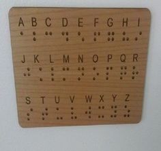 a wooden typewriter board mounted on the wall with letters and numbers written in cursive writing