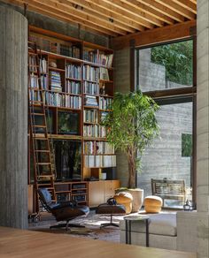 a living room filled with furniture next to a tall wooden book shelf covered in books