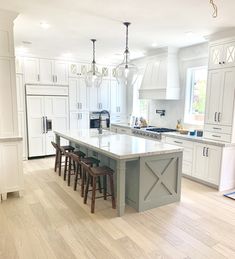 a large kitchen with white cabinets and an island