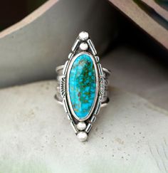 Unique, bold turquoise ring for her. The setting is a Kingman, deep blue turquoise oval surfboard cabochon that is 1.75" x 5.8" and in a Bezel embellished setting. The 925 Sterling Silver has been fused, stamped and oxidized. The tapered wide band is 3/4" then narrows to 1/8" and cannot be resized. Size 8 This handmade boho chic statement ring is one of a kind showcasing the beauty of Kingman Turquoise. Whether you're shopping for yourself or are searching for the one of a kind gift for mom, wife, girlfriend or friend look no further.  The holidays are right around the corner so shop early for the best selection. Caring for your turquoise jewelry:  To protect your turquoise jewelry, we recommend that you put jewelry on after applying makeup, sunscreen and perfume, and never wear your jewel Sterling Silver Birthstone Ring, Turquoise Statement Ring, Casual Rings, Vero Beach Fl, Southwest Jewelry, Precious Jewels, Vero Beach, Statement Ring Silver, Kingman Turquoise