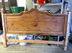 a wooden bed frame in a garage with buckets on the floor