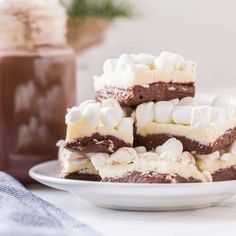 chocolate marshmallows are stacked on top of each other in a white plate