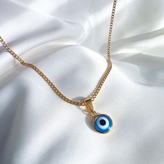 A dainty, modern evil eye necklace crafted to perfection. Made up of 18K gold filled, shimmering white and blue enamel - this necklace has a powerful meaning. Perfect for layering, or wearing on its own, this evil eye necklace will protect you from all.  #Gold #fashion #Jewelry #Necklace #Pendant Do not wear it to the pool, spa, or the beach. - Remove when sleeping or exercising. - Avoid contact with perfumes, body oils and other chemicals, including household cleaners. - Do not use chemical jewelry cleaners. - Gently polish with a soft, lint-free cloth. Please do not use a metal polishing cloth. - Store your jewelry in a cool dry place. Blue Adjustable Chain Necklace As Gift, Blue Gold Plated Chain Necklace As Gift, Dainty Blue Necklaces With Charms, Blue Gold Plated Charm Necklace As Gift, Blue Pendant Chain Necklace With Delicate Chain, Dainty Blue Chain Necklace For Gift, Gold Chain Necklace With Evil Eye As Gift, Blue Dainty Charm Necklaces, Blue Pendant Necklace With Delicate Chain