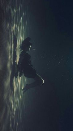 a woman is floating in the water at night