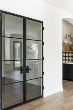 an empty room with glass doors and wood flooring