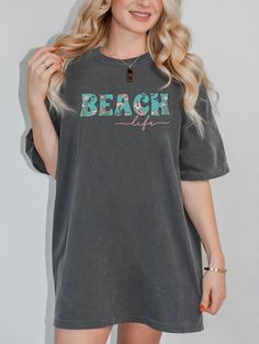 "Get ready to enter vacay mode and enjoy the sunshine this Summer with our cute beach life tee. This t-shirt is available in 4 beautiful colors for you to choose from. It has a relaxed fit and, if you order 2 sizes up from your normal size, you get that trendy oversized look.  KEY FEATURES: *Super comfy 100% ring-spun cotton, without side seams *Medium fabric (6.1 oz/yd² (206.8 g/m *Relaxed fit *Garment-dyed fabric gives a soft feel and colors, for that retro look *Double stitching which makes your cute tee last longer CARE INSTRUCTIONS: *Machine wash: cold (max 30C or 90F) *Do not bleach *Tumble dry: low heat *Iron, steam or dry: low heat *Do not dryclean COLOR DISCLAIMER:  Please note that colors shown in our product images may vary slightly and differ from the final product, as variatio Soft-washed Summer Beach T-shirt, Cute Beach Tops For Vacation, Spring Vacation Soft-washed Tops, Soft-washed Graphic Tee For Vacation, Cute Tops For Beach Season Vacation, Cute Relaxed Fit T-shirt For Beach Season, Oversized Relaxed Tops For Beach Season, Relaxed Oversized Tops For Beach Season, Beachy Tops With Graphic Print For Day Out