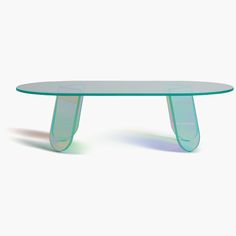 an oval glass table with curved legs on the top and bottom, against a white background