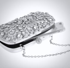 Complete your stunning bridal look with the perfect handbag! Practical and stylish, this evening clutch features rhinestones and pearls swirling in an eye-catching design. Color is a soft gray with silver metal trim. Comes with a removable shoulder chain. Dimensions - Length: 6.25" (approx. 16cm); Height: 4" (approx.10cm); Width: 2" (approx. 5cm). Silver Evening Bag With Pearl Handle For Wedding, Silver Embellished Clutch For Formal Occasions, Silver Evening Bag With Pearl Handle For Formal Occasions, Silver Evening Bag With Pearl Handle For Formal Events, Silver Rectangular Evening Bag For Wedding Guest, Embellished Silver Evening Bag For Events, Silver Embellished Evening Bag For Events, Silver Bags With Rhinestones For Wedding Guest, Silver Clutch Bag For Wedding Guest